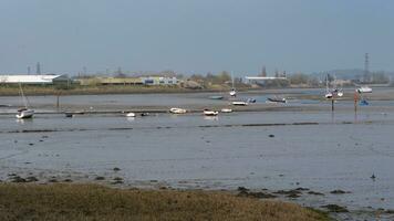 niedrig Tide Fluss mit Boote ruhen auf das Wattenmeer foto