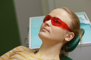 Frau im rot Sicherheit Brille im Dental Büro foto