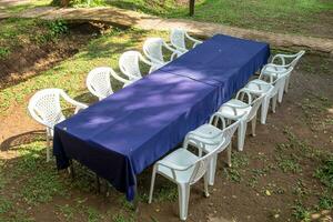 Blau Tischdecke mit Weiß Stuhl ordnen natürlich foto