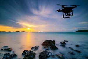 Silhouette einer Drohne, die über das Meer fliegt