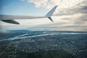 Aussicht von Flugzeug mit überfüllt Innenstadt und groß Fluss in Verbindung gebracht zu das Meer foto