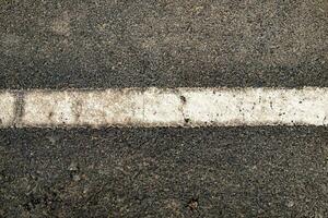 Weiß Linie auf schwarz Straße texturiert foto