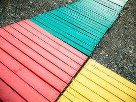 bunt hölzern Pfad auf ein steinig Strand. foto