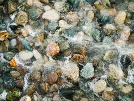 schön Kieselsteine unter Wasser mit Schaum foto