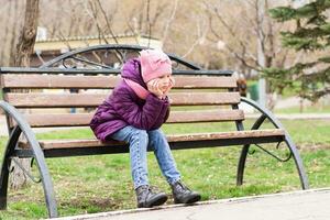 ein einsam Mädchen sitzt mit ein traurig Gesicht auf ein Park Bank. mental Gesundheit. Teenager Jahre foto