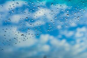 Regentropfen stecken zu das Glas gegen das Hintergrund von das Himmel. wo das Regen hat gerade fertig fallen, ist ein Neu Bild benutzt wie ein Hintergrund foto