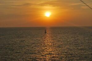 ein Yacht beim Sonnenuntergang auf das Meer Oberfläche. Sonnenuntergang mit ein Yachten Silhouette, Thailand foto
