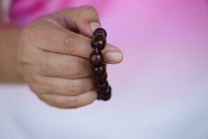 schließen oben Hand hält Perlen Armband, Zählen zum tun Meditationskonzept, Mode Zubehör. religiös Amulett zum Glück, können Sein benutzt im tun Meditation oder beten Ritual. Kultur von Glaube. foto