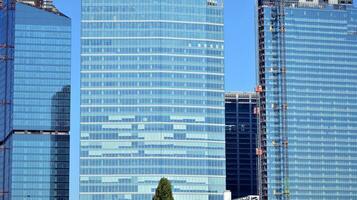 modern Büro Gebäude mit Glas Fassade auf ein klar Himmel Hintergrund. transparent Glas Mauer von Büro Gebäude. foto