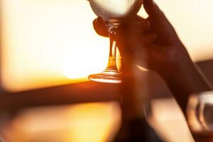 Weinglas im weiblich Hand gegen das Sonnenuntergang foto