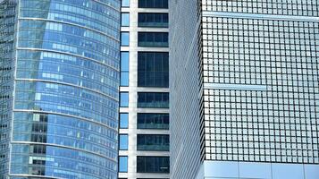 abstrakt Fragment von zeitgenössisch die Architektur, Wände gemacht von Glas und Beton. abstrakt Nahansicht von das glasverkleidet Fassade von ein modern Gebäude bedeckt im reflektierend Teller Glas. foto