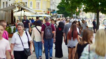 Warschau, Polen. 29 Juli 2023. Menge von Menschen Gehen auf ein Straße. ein Menge ziehen um gegen ein Hintergrund von ein städtisch alt Stadt Landschaft. foto