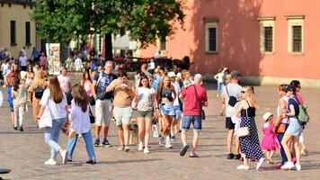 Warschau, Polen. 29 Juli 2023. Menge von Menschen Gehen auf ein Straße. ein Menge ziehen um gegen ein Hintergrund von ein städtisch alt Stadt Landschaft. foto