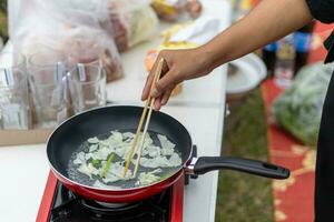 Hände von ein Frau Wer ist Kochen im Camping Aktivitäten foto