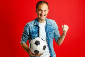 gut aussehend Mann halten ein Fußball Ball Über bunt Backgound foto