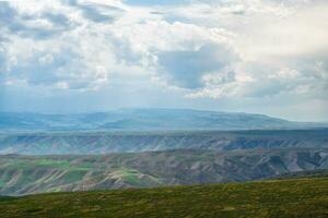 Wiese und Berge im ein wolkig Tag. Foto im kalajun Wiese im Xinjiang, China.