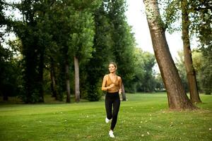 ziemlich jung Frau Laufen im das Park foto