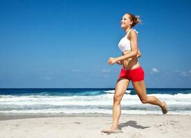 gesunde Frau läuft am Strand foto