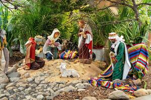 Weihnachten Geburt Szene umgeben durch Grün Palme Blätter mit Keramik Figuren foto