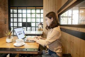 schöne Geschäftsfrau arbeitet mit ihrem Laptop im Café in