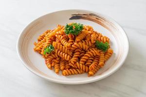 Spiral- oder Spirali-Nudeln mit Tomatensauce und Wurst - italienische Küche foto