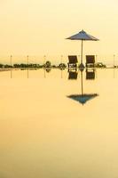 schöner Sonnenschirm und Stuhl um den Pool im Hotel und Resort? foto