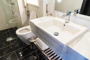 weiße Waschbecken- und Wasserhahndekoration im Badezimmer foto