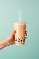 ein Hand halten wegbringen Plastik Tasse von köstlich vereist Blase Milch Tee und schwarz Perlen. ai generiert foto