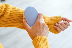 Frau im Gelb Sweatshirt mit Stoff Tabletten entfernen Werkzeug foto