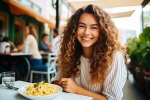 Mädchen isst Pasta im Straße Cafe foto