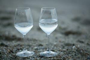 zwei Brille von Wasser auf das Strand foto