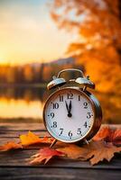 Alarm Uhr ruht auf Herbst Blätter gegen ein Hintergrund von natürlich Landschaft foto