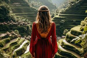 ein jung weiblich Tourist im ein rot Kleid bewundern das atemberaubend Tegalalang Reis Terrasse im bali Indonesien foto