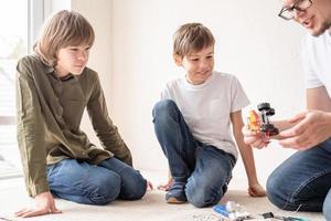 Jungen und Lehrer, die Spaß daran haben, Roboterautos in der Werkstatt zu bauen