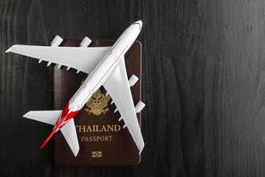 Flugzeugmodell und Reisepass auf Holzschreibtisch, fertiges Reisekonzept foto
