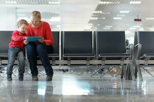 jung Mutter und Sohn im ein Flughafen Terminal foto