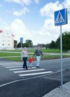 Familie von drei Kreuzung das Straße. foto