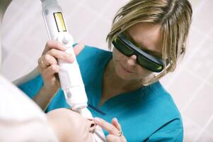 Kosmetikerin tun Laser- Haut Behandlung foto