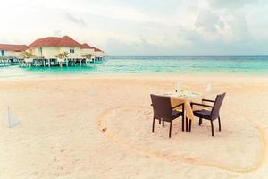 leerer Esstisch und Stuhl am Strand mit Meerblick im Hintergrund auf den Malediven?