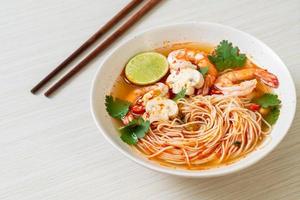 Nudeln mit scharfer Suppe und Garnelen in weißer Schüssel, oder Tom Yum Kung - asiatische Küche foto