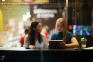 zwei weiblich freunde mit Tablette pc im ein Cafe foto