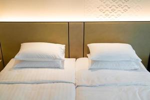 weiße Kissendekoration auf dem Bett im Hotelresortschlafzimmer
