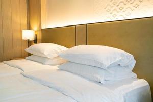 weiße Kissendekoration auf dem Bett im Hotelresortschlafzimmer