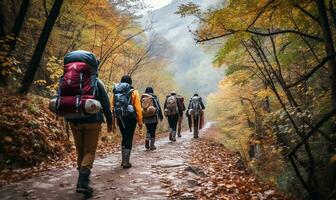 Gruppe von Rucksacktouristen Trekking auf das Straße im ein Herbst Wald. ai generiert foto