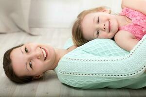 lächelnd Mutter und Tochter auf das Fußboden foto
