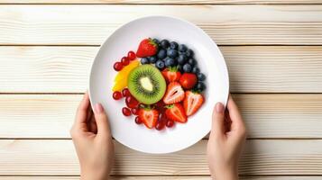 oben Aussicht von Obst Salat mit Erdbeere und Blaubeere Süss Kirsche im Teller auf Holz Hintergrund, ai generativ. foto