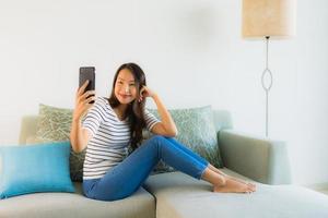 Porträt schöne junge asiatische Frau, die Handy benutzt oder spricht foto