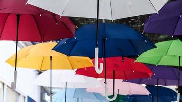 Straße mit farbigen Regenschirmen geschmückt. Viele Regenschirme färben den Himmel in der Stadt foto