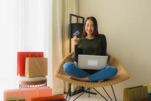 Portrait schöne junge asiatische Frauen mit Computer-Laptop oder Smart und Handy mit Kreditkarte für Online-Shopping foto