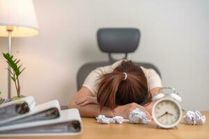 betont Frau haben müde und schläfrig während Arbeiten, weiblich Geschäftsfrau haben Kopfschmerzen beim Büro, erschöpft Frau mit Unterlagen Mappe Stapel und Uhr beim Zuhause spät Nacht. überarbeitet und im Laufe der Zeit foto